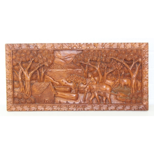 442 - An Asian carved relief hardwood panel depicting elephants and jungle, marked made in Thailand, 63cm ... 