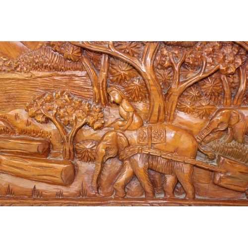 442 - An Asian carved relief hardwood panel depicting elephants and jungle, marked made in Thailand, 63cm ... 