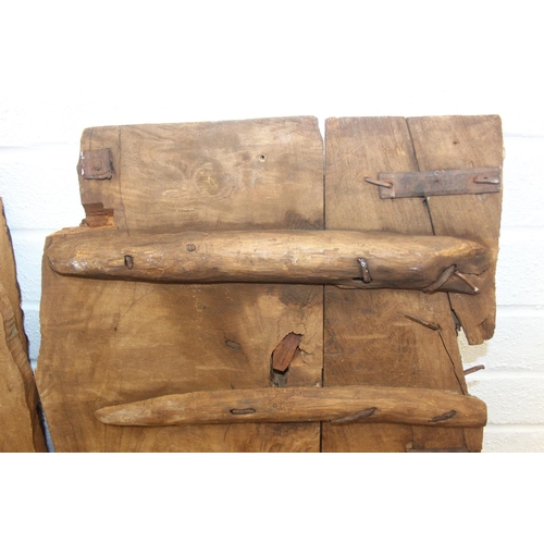 75 - A pair of antique hardwood doors with brass roundels, believed to be Indonesian and made from teak, ... 