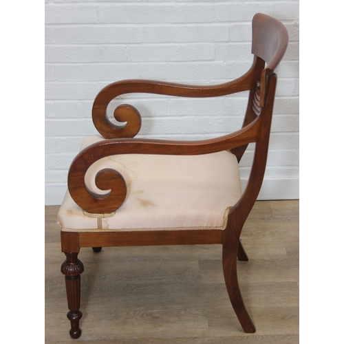 65 - An antique Regency style carved armchair with decorative scroll arms, carved back and turned and car... 