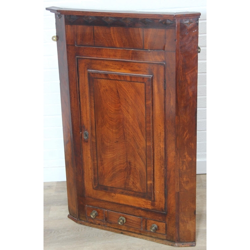 69 - A Georgian mahogany corner cupboard with a central drawer to bottom frieze flanked by two faux drawe... 