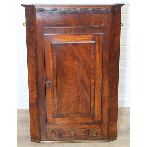 69 - A Georgian mahogany corner cupboard with a central drawer to bottom frieze flanked by two faux drawe... 