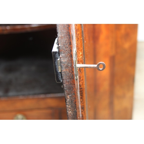 69 - A Georgian mahogany corner cupboard with a central drawer to bottom frieze flanked by two faux drawe... 