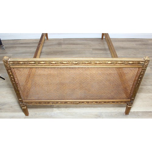 64 - A vintage single bed with gold painted carved wooden and bergère head and foot boards, side boards b... 