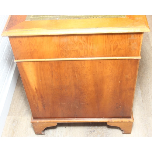 107 - A vintage Yew wood pedestal desk with inset green leather top, 120cm x 61cm x 77cm