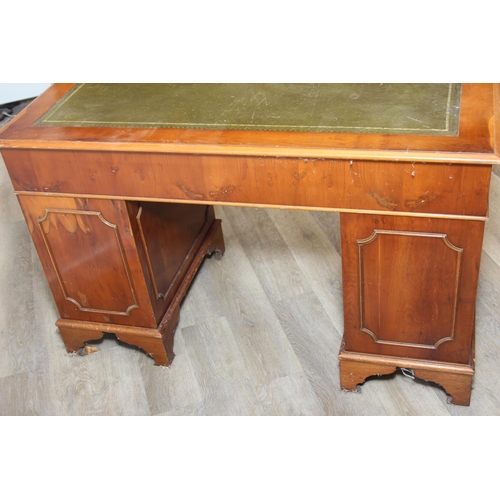 107 - A vintage Yew wood pedestal desk with inset green leather top, 120cm x 61cm x 77cm