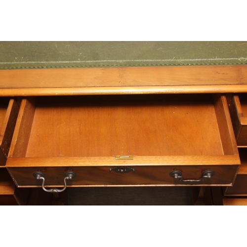 107 - A vintage Yew wood pedestal desk with inset green leather top, 120cm x 61cm x 77cm