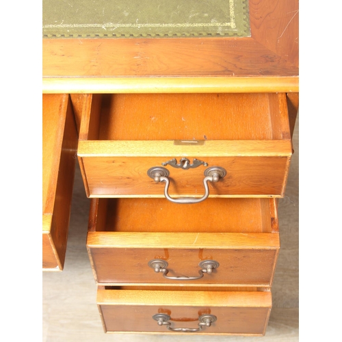 107 - A vintage Yew wood pedestal desk with inset green leather top, 120cm x 61cm x 77cm