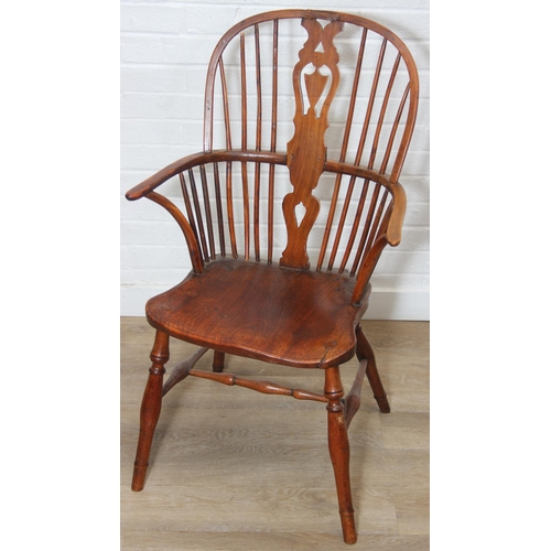 109 - An antique elm seated Thames Valley or Windsor farmhouse armchair with stick back and decorative spl... 