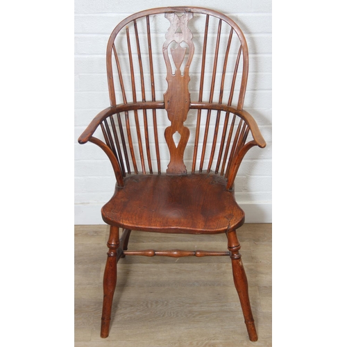 109 - An antique elm seated Thames Valley or Windsor farmhouse armchair with stick back and decorative spl... 