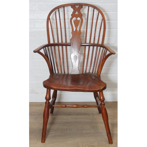 109 - An antique elm seated Thames Valley or Windsor farmhouse armchair with stick back and decorative spl... 