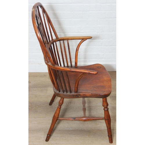 109 - An antique elm seated Thames Valley or Windsor farmhouse armchair with stick back and decorative spl... 