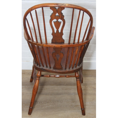 109 - An antique elm seated Thames Valley or Windsor farmhouse armchair with stick back and decorative spl... 