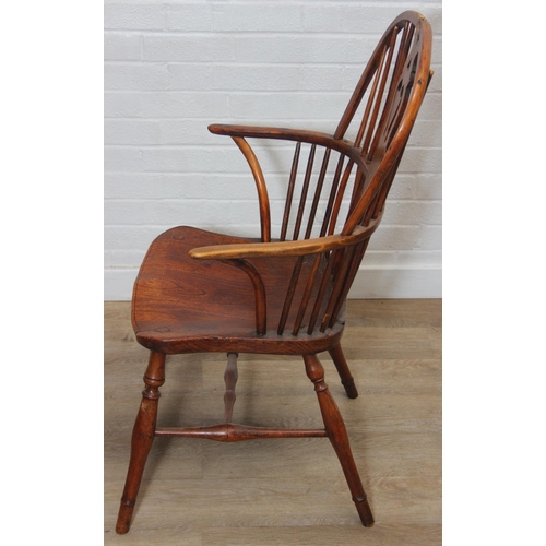 109 - An antique elm seated Thames Valley or Windsor farmhouse armchair with stick back and decorative spl... 