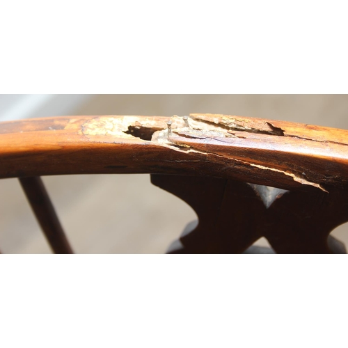 109 - An antique elm seated Thames Valley or Windsor farmhouse armchair with stick back and decorative spl... 