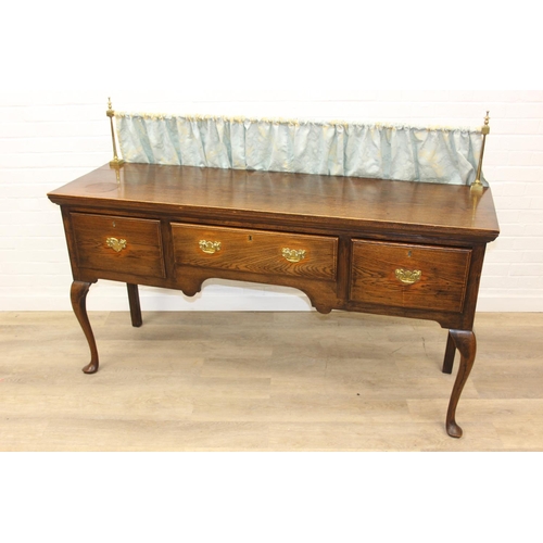 62 - A Georgian style oak sideboard with three deep drawers and brass curtained rail, early 20th century,... 