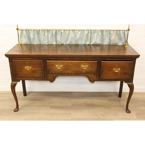 62 - A Georgian style oak sideboard with three deep drawers and brass curtained rail, early 20th century,... 