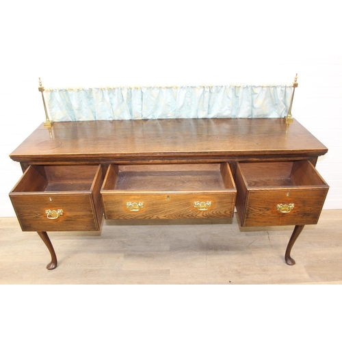 62 - A Georgian style oak sideboard with three deep drawers and brass curtained rail, early 20th century,... 