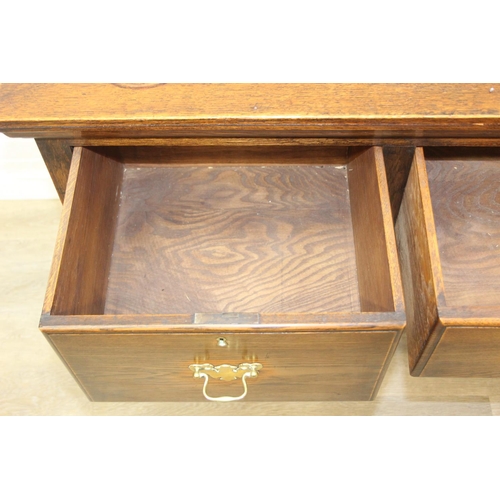 62 - A Georgian style oak sideboard with three deep drawers and brass curtained rail, early 20th century,... 