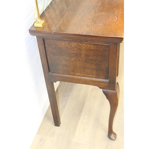 62 - A Georgian style oak sideboard with three deep drawers and brass curtained rail, early 20th century,... 