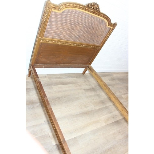 64 - A vintage single bed with gold painted carved wooden and bergère head and foot boards, side boards b... 