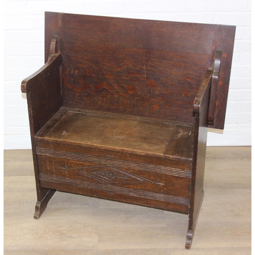 61 - A vintage oak metamorphic monk's bench with carved detail to front panel, the bench has a hinged sea... 