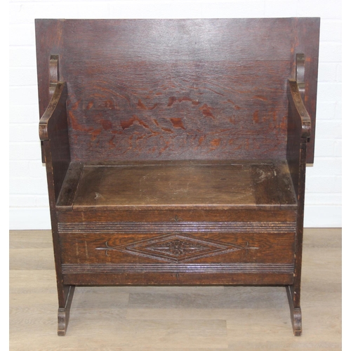 61 - A vintage oak metamorphic monk's bench with carved detail to front panel, the bench has a hinged sea... 
