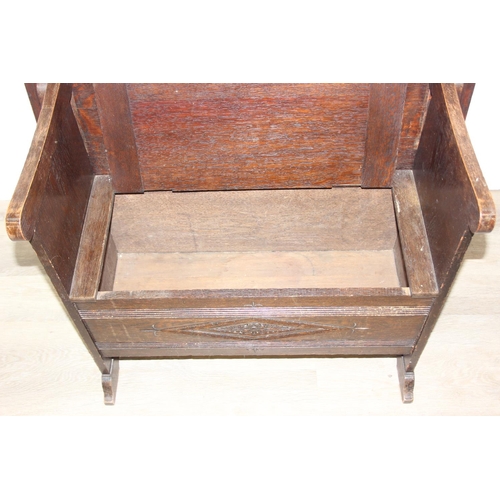 61 - A vintage oak metamorphic monk's bench with carved detail to front panel, the bench has a hinged sea... 