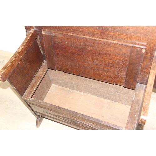 61 - A vintage oak metamorphic monk's bench with carved detail to front panel, the bench has a hinged sea... 
