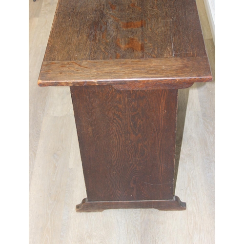 61 - A vintage oak metamorphic monk's bench with carved detail to front panel, the bench has a hinged sea... 