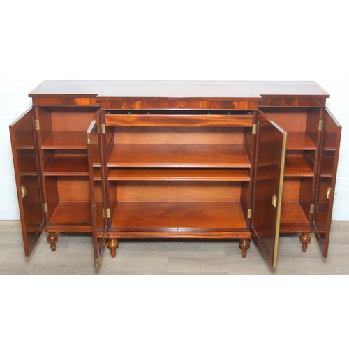 20 - William Tillman Furniture - a Regency style flame Mahogany sideboard, four doors with the central pa... 