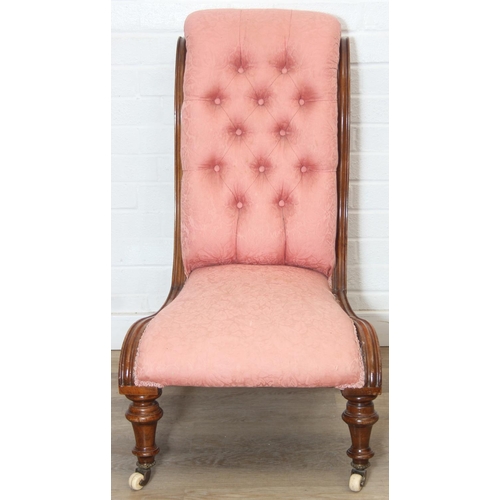118 - A Victorian period nursing chair with pink button back upholstery, exposed mahogany frame and brass ... 