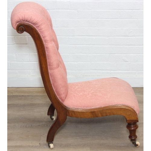 118 - A Victorian period nursing chair with pink button back upholstery, exposed mahogany frame and brass ... 