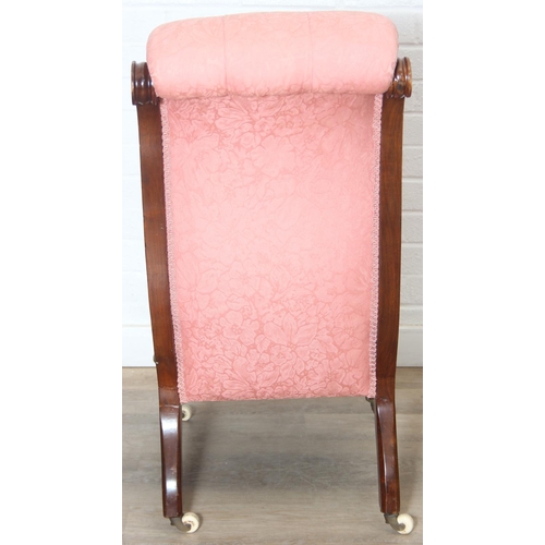 118 - A Victorian period nursing chair with pink button back upholstery, exposed mahogany frame and brass ... 