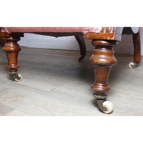 118 - A Victorian period nursing chair with pink button back upholstery, exposed mahogany frame and brass ... 