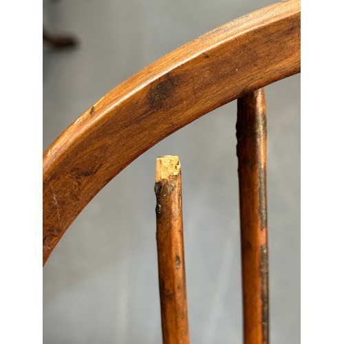 109 - An antique elm seated Thames Valley or Windsor farmhouse armchair with stick back and decorative spl... 
