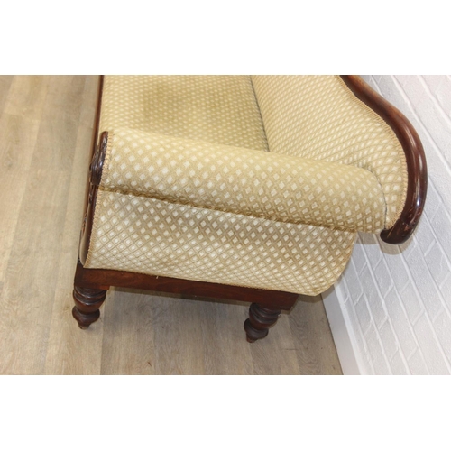 68 - A Victorian roll end sofa or settee with exposed mahogany frame, buff upholstery, 224cm long x 94cm ...