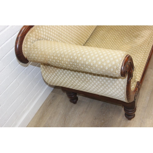 68 - A Victorian roll end sofa or settee with exposed mahogany frame, buff upholstery, 224cm long x 94cm ...