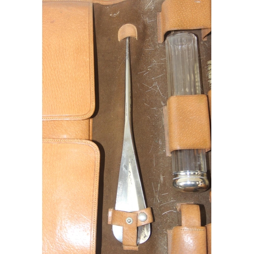 1006 - A leather cased gentleman's travelling vanity set, harlequin pieces but to include four silver toppe... 