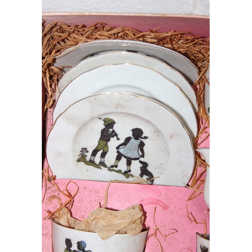612 - A vintage boxed child's or dolls tea set decorated with scenes of children, with original straw fill... 