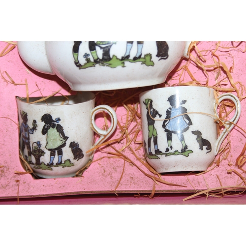 612 - A vintage boxed child's or dolls tea set decorated with scenes of children, with original straw fill... 