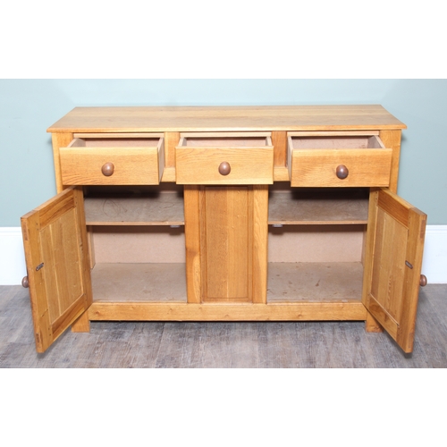 14 - A modern light oak three drawer two door sideboard made by Neil Thompson, 156cm x 55cm x 101cm
