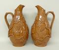 A pair of stoneware harvest jugs, mid 19th century, with raised vine leaf decoration, one with the f... 