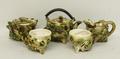 A Continental pottery tea set of shell form in green and brown, comprising teapot, sugar bowl, milk ... 