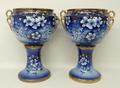 A pair of pottery jardinieres and stands of twin handled form, decorated in blue and white with flow... 