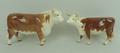 A Beswick Hereford bull and cow, brown gloss, 15 and 13cm high.