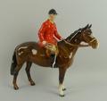 A Beswick pottery figure modelled as a huntsman in red jacket on a brown horse, 24 by 22cm.