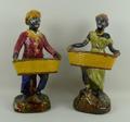 A pair of majolica Blackamoor figures, late 19th century, each modelled holding a twin handled baske... 