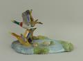 A Royal Crown Derby porcelain figure group of Mallards modelled flying from a pond, printed and pain... 