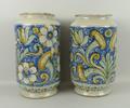A pair of Maiolica albarello vases painted with flowers on a blue ground, 19 by 31cm high.